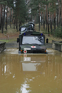 5 Unimog-KrKw vor der Einfahrt ins Wasser
